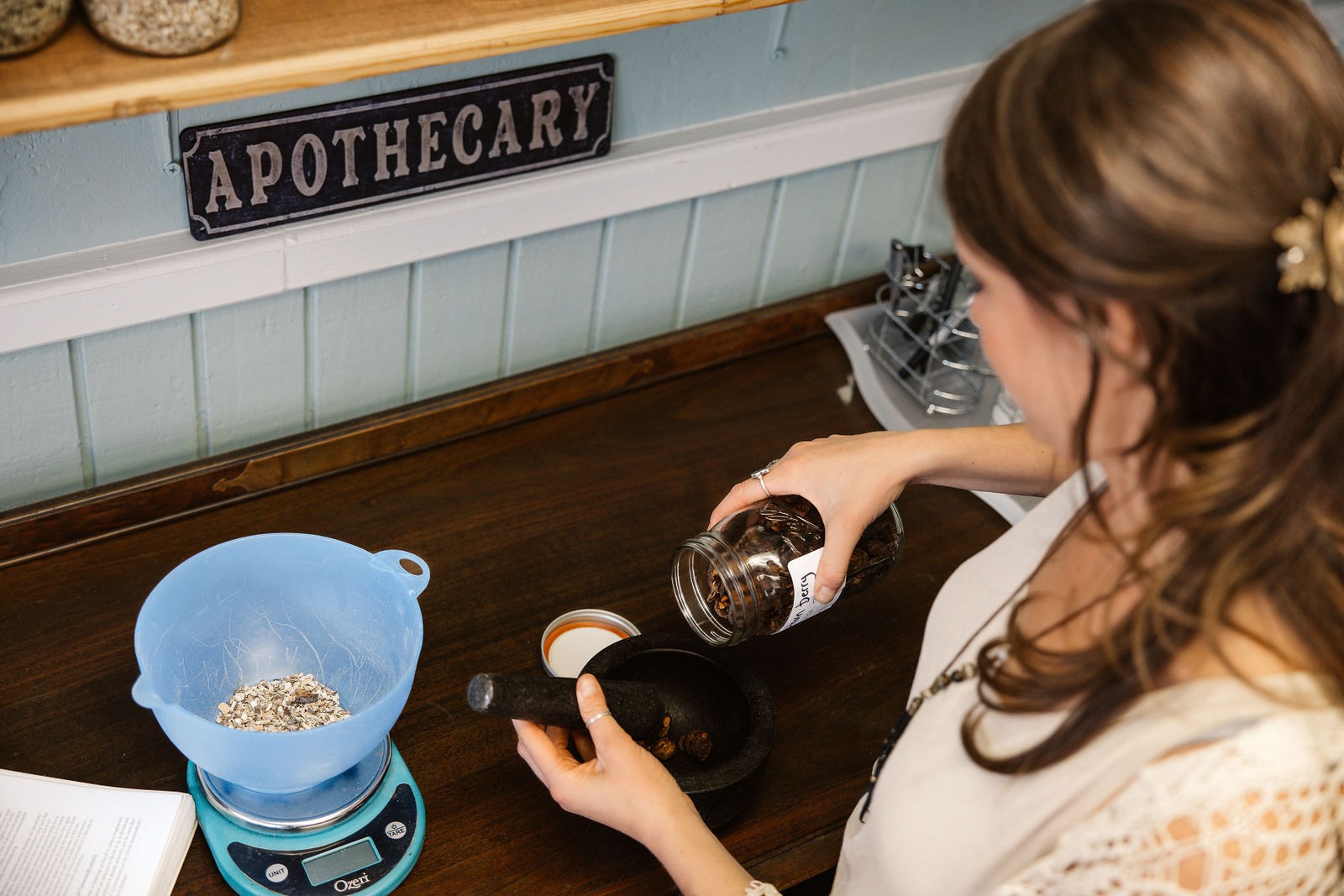 Elena preparing herbal formulas in the apothecary
